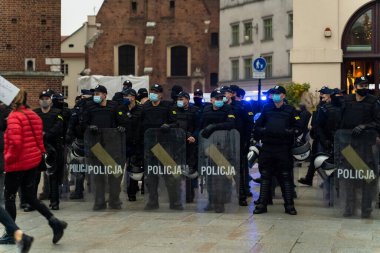 Krakow, Polonya - 25 Ekim 2020: Salgın sırasında maske takan Polonya polisi, ana şehir merkezinde kürtajın tamamen yasaklanmasını protesto ederken kanun ve düzeni sağlamak için