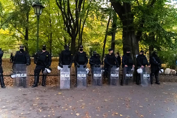 ポーランドのクラクフ 2020年10月25日 大都市中心部での中絶の全面禁止の立法提案に抗議するために パンデミックの際にマスクを着用して警察が一緒に立っている — ストック写真