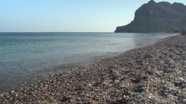 Rodos, Yunanistan: Yaz mevsiminde deniz / sahil taşlarıyla gündüz dalgalarına karşı çekim.