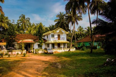 Goa, india - October 24, 2018: A middle class house built on portuguese theme around palm trees in exotic location against blue sky