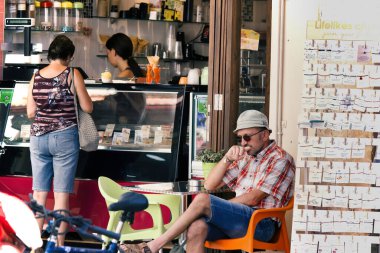 Girit, Yunanistan - 16 Eylül 2017: Bir dondurma dükkanı ve Avrupa 'daki Agios Nikolaos' un şehir merkezinin dışında oturan müşteri.