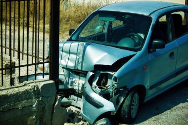 Kreta or Crete, Greece - September 11, 2017: An unidentified abandoned crashed car damaged after accident due to collision with concrete fence. Close up shot of a front part of a Car accident clipart
