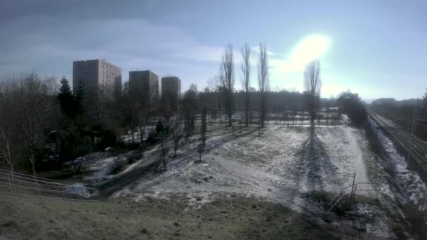 波兰克拉科夫 冬季公园的一盘照片 雪地覆盖在铁路轨道旁边的阳光和高大的树木上 — 图库视频影像