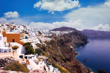 Santorini, Yunanistan - 11 Eylül 2017: Dağda Akdeniz kıyısında dramatik gökyüzüne karşı beyaz evler bulunan kentin geniş açılı görüntüsü