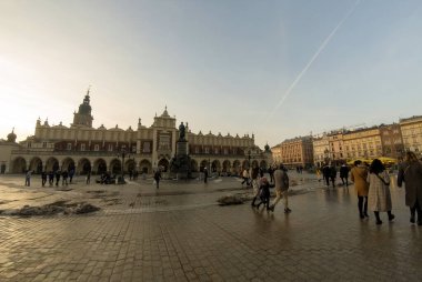 Krakow, Polonya - 22 Şubat 2021: Kumaş Salonu Panoraması (Sukiennice) - Main Square (Plac Mariacki) 'de yer alan ve el işi pazarı olarak hizmet veren ve şehir merkezinde yürüyen insanlar