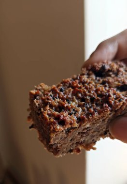 Ev yapımı protein barın yakınında chia tohumu, yulaf ve fındık var. Sağlıklı ev yapımı atıştırmalıklar.