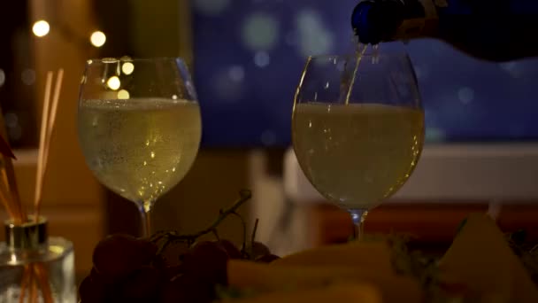 ビュッフェテーブルの上に白いスパークリングワインでいっぱいのワイングラスの泡 新年とクリスマスのお祝いのテーマのコンセプトを示す透明なガラスに白ワインを提供または注ぎます — ストック動画