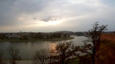 Krakow, Polonya: Şiddetli rüzgarlar ve kentsel kentlerdeki binalara karşı vistül nehri ve Avrupa 'daki karanlık bulutların arkasında yavaşça saklanan ağaçların geniş açılı hava görüntüsü