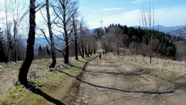 ポーランド リマノワ Limanowa 青い空を背景に照りつけるような木々に囲まれたライサ Beskid Wyspowy の未舗装の道でハイキングやトレッキングをする人々 — ストック動画