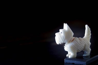 Siyah arka planda izole edilmiş, dişi Yorkshire Teriyeri 'nin sevimli beyaz köpeğinin plastik küçük figürünün makro yakın plan çekimi. Metin alanını kopyala yapıştır ile aşırı seçici odak