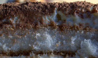 Tiramisu adında tatlı İtalyan pastası ya da pastası yapan katmanlı bir şeklin makro görüntüsü..