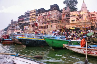 Varanasi, Hindistan - 16 Mart 2019: Dashashwamedh Ghat yakınlarındaki Ganga nehrinde bir grup ahşap tekne. Uttar Pradesh eyaletindeki antik şehir mimarisi.