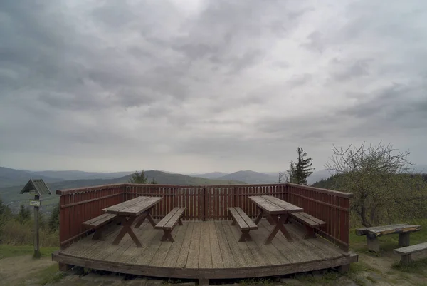 Wide angle view on top of Polish mountains named Lubon Wielki with wooden chairs to sit next to viewpoint located in the region of Beskid Wyspowy close to the town of Rabka Zaryte in South Poland