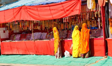 Pushkar, Hindistan - 10 Kasım 2016: Geleneksel Hintli bir grup kadın, Rajasthan eyaletindeki Pushkar fuarının ticari caddesinde sari satın alıyor veya alışveriş yapıyor.