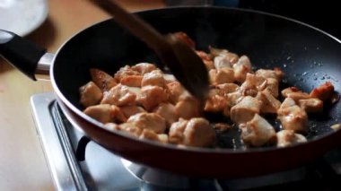 Makro yakın plan tavuk parçaları, yağlı ve baharatlı pişirilip kızartılıyor, tavada taze et pişiriliyor, seçici bir odak noktası var..