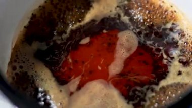 Sıcak kaynamış masala Hint çayına süt dökmenin seçici odak noktasını kapat. Hazırlık sürecinde sütle çayın karıştırılması sonucu oluşan renk ve karşıtlık patlaması.