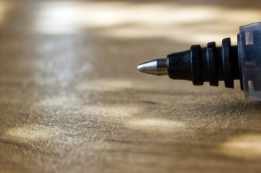 Tahta zemine karşı tükenmez kalem ucunun aşırı yakın çekim görüntüsü