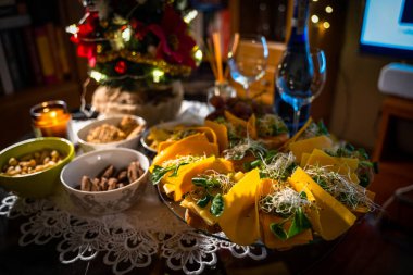 Snacks for wine on the buffet table. Cold snacks such as cookies, nuts, sandwiches with salmon and cheese and nachos. Party snacks table showing christmas or new year celebration concept clipart