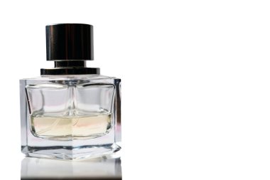 Beyaz arka planda, şeffaf, sıcak renkli, yarısı dolu bir parfüm şişesi. Moda ürünü konsepti.