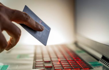 Erkekler online alışveriş siparişi vermek için kredi kartı ve ödeme bilgilerini klavyede tutuyorlar. İnternet teknolojisi ve Dijital Pazar yeri E-Ticaret yaşam tarzı konsepti, Satın Alma işlemi