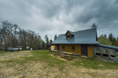 Wielki Lubon, Polonya - 15 Temmuz 2021: Yürüyüş yapmayı seven insanlar için turistik bir yer olan Beskid Wyspowy 'de bulutlu yağmurlu bir havada Polonya dağının zirvesinde yer alan bir barınak