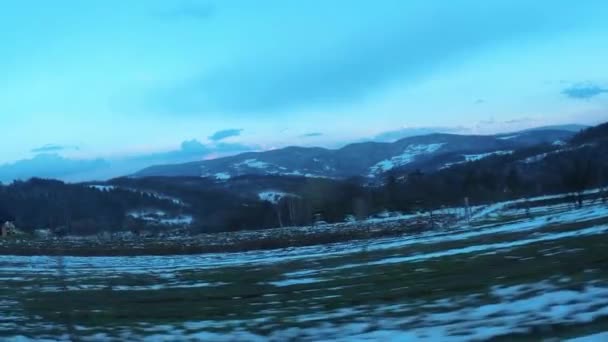 从一辆行驶中的汽车通过侧窗俯瞰波兰山景 冬季房屋与雪山相对照的场景 — 图库视频影像