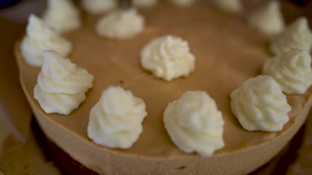 搅拌器准备庆祝奶油焦糖蛋糕与白色奶油 烹饪专家们手忙脚乱地把奶油压在一个大的白蛋糕上 大生日蛋糕或婚礼 — 图库视频影像