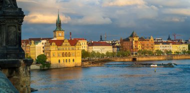 Prag Vltava Nehri manzarası tarihi sarı saat kulesi binası ve renkli rıhtım mimarisi Çek Cumhuriyeti manzaralı nehir manzaralı
