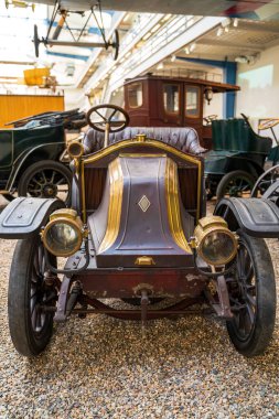 Prag, Çek Cumhuriyeti - 1 Mayıs 2023: Müze benzeri bir ortamda sergilenen bir retro otomobil. Pirinç aksanlar, boyayı yıpratmak ve klasik ışıklandırma tarihi ulaşım için nostalji uyandırıyor.