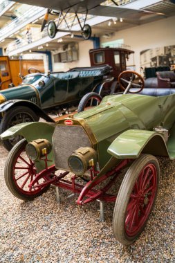 Prag, Çek Cumhuriyeti - 1 Mayıs 2023: Yeşil bir Bugatti roadster, pirinç lambalar, kırmızı çizgili tekerlekler ve ahşap direksiyonlu bir Bugatti aracının yer aldığı Çek müzesinde tarihi otomobil sergileniyor.