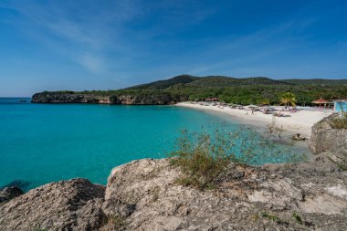 Mavi denizi ve turkuaz suyu olan güzel bir sahil.