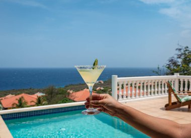Sahilde kokteyl içen bir kadın.