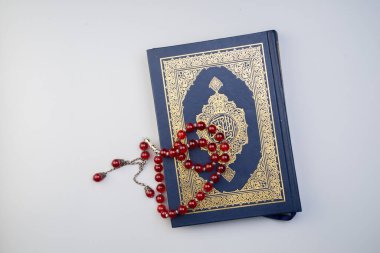 Ramazan Kareem, Bayram Mübarek veya İslami kavram. İslami kutsal kitap, Kuran ya da Kuran, gri arka planda tespih ya da tasbih ile. Kitabın üzerindeki Arapça kelimeler kutsal Kur 'an anlamına gelir..