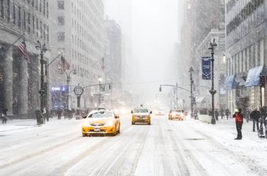 New York 'ta kar fırtınası var. Şiddetli kar yağışı var. Arabalar Manhattan' daki kar fırtınası sırasında karla kaplı..