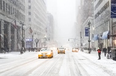 New York 'ta kar fırtınası var. Şiddetli kar yağışı var. Arabalar Manhattan' daki kar fırtınası sırasında karla kaplı..