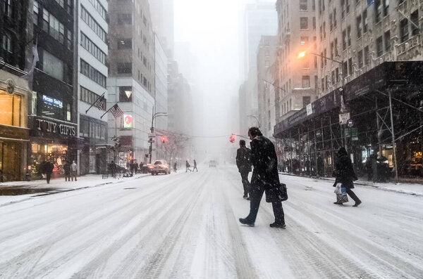 Winter snowstorm blizzard in New York City with heavy snow fall, cars covered in snow in Manhattan. New York, USA.