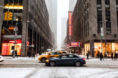 New York 'ta kar fırtınası var. Şiddetli kar yağışı var. Arabalar Manhattan' daki kar fırtınası sırasında karla kaplı..