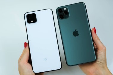 Google Piksel 4 XL açık beyaz renkli ve iPhone 11 Pro Max gece yarısı yeşil yanyana.