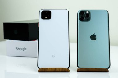Google Piksel 4 XL açık beyaz renkli ve iPhone 11 Pro Max gece yarısı yeşil yanyana.