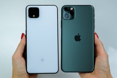 Google Piksel 4 XL açık beyaz renkli ve iPhone 11 Pro Max gece yarısı yeşil yanyana.