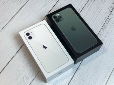 iPhone 11 Pro Max gece yarısı yeşil kutuda iPhone 11 'in yanında beyaz kutuda.