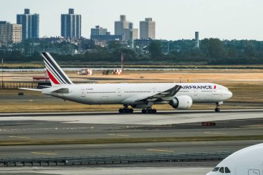 Air France Boeing 777-328/ER Registration F-GSQM taking off from the runaway at the John F. Kennedy International Airport (JFK Airport) as seen from the TWA Hotel. Queens New York clipart