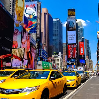Times Meydanı 'nda sarı New York taksileri renkli reklam panolarından geçiyor. Manhattan, New York.