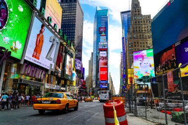 Times Meydanı 'nda güzel bir yaz günü, sarı New York taksileri renkli reklam panolarının içinden geçiyor. Manhattan, New York.
