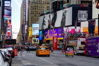 Times Meydanı 'nda sarı New York taksileri renkli reklam panolarından geçiyor. Manhattan, New York.