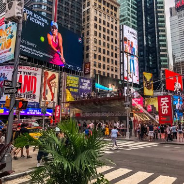 Times Meydanı 'nda güzel bir yaz günü, sarı New York taksileri renkli reklam panolarının içinden geçiyor. Manhattan, New York.
