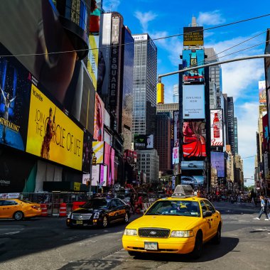 Times Meydanı 'nda sarı New York taksileri renkli reklam panolarından geçiyor. Manhattan, New York.