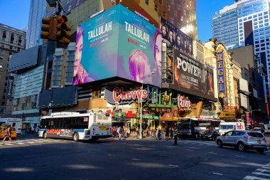 Times Meydanı 'nda sarı New York taksileri renkli reklam panolarından geçiyor. Manhattan, New York.