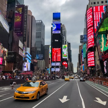 Times Meydanı 'nda sarı New York taksileri renkli reklam panolarından geçiyor. Manhattan, New York.