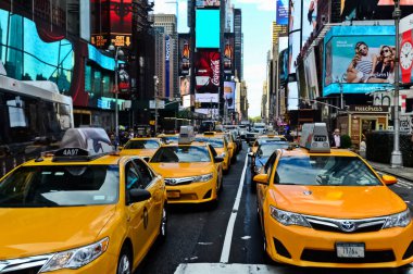 Times Meydanı 'nda sarı New York taksileri renkli reklam panolarından geçiyor. Manhattan, New York.